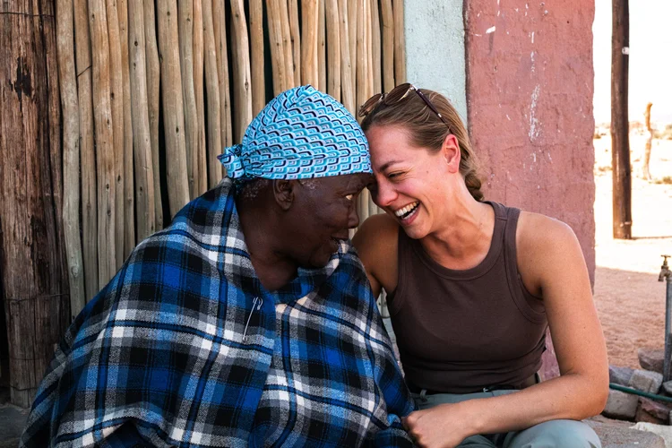 Amber deelt een warme, lachende ontmoeting met een lokale vrouw in Namibië